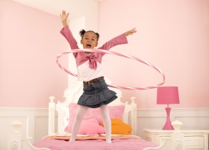 Young Girl Hula Hooping on Her Bed
