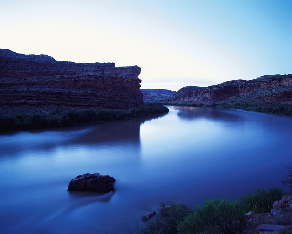 Calm, still water in a wide river at dusk
